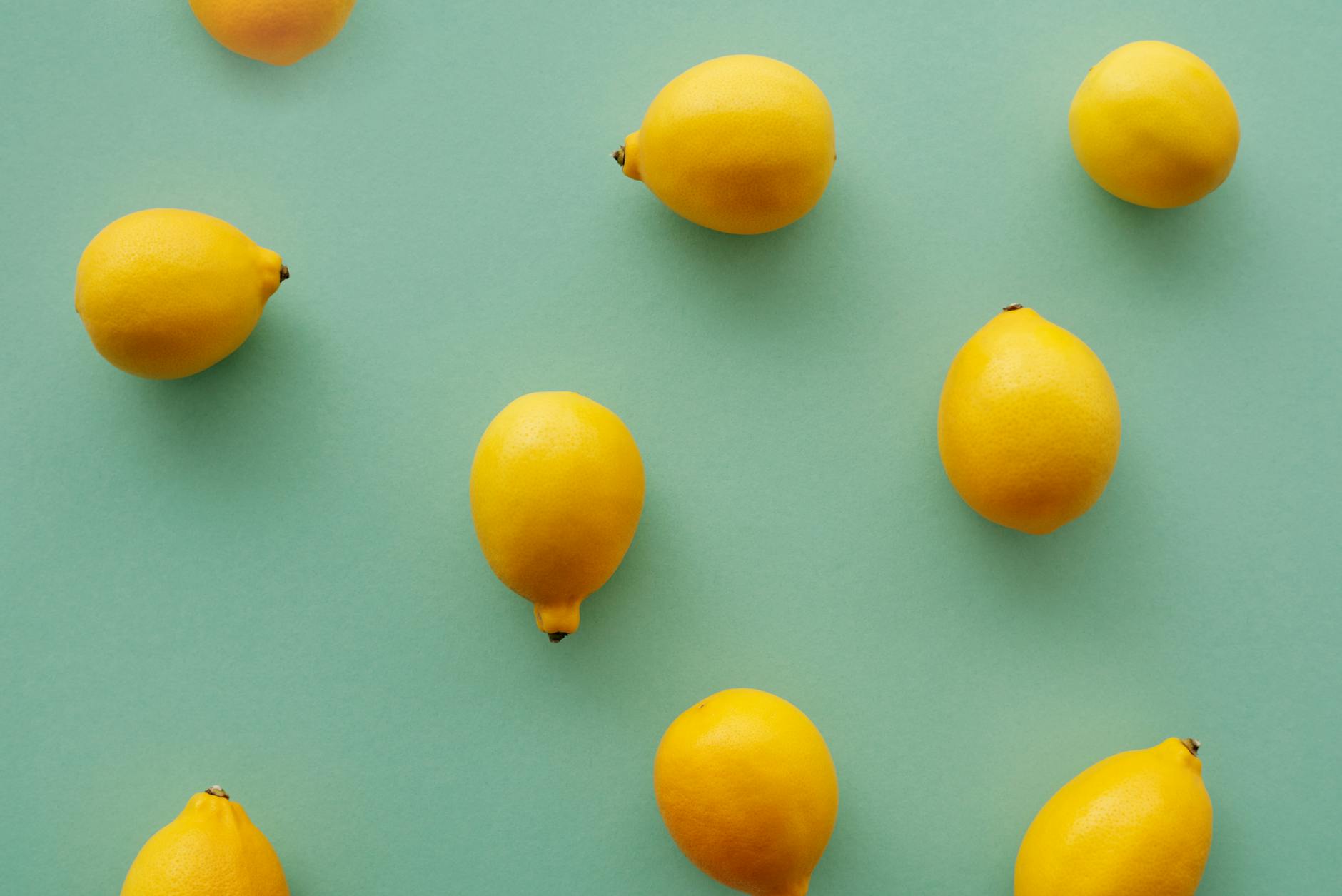 Bright yellow lemons arranged on a pastel green background, representing fresh sensation recovery and pleasure rediscovery