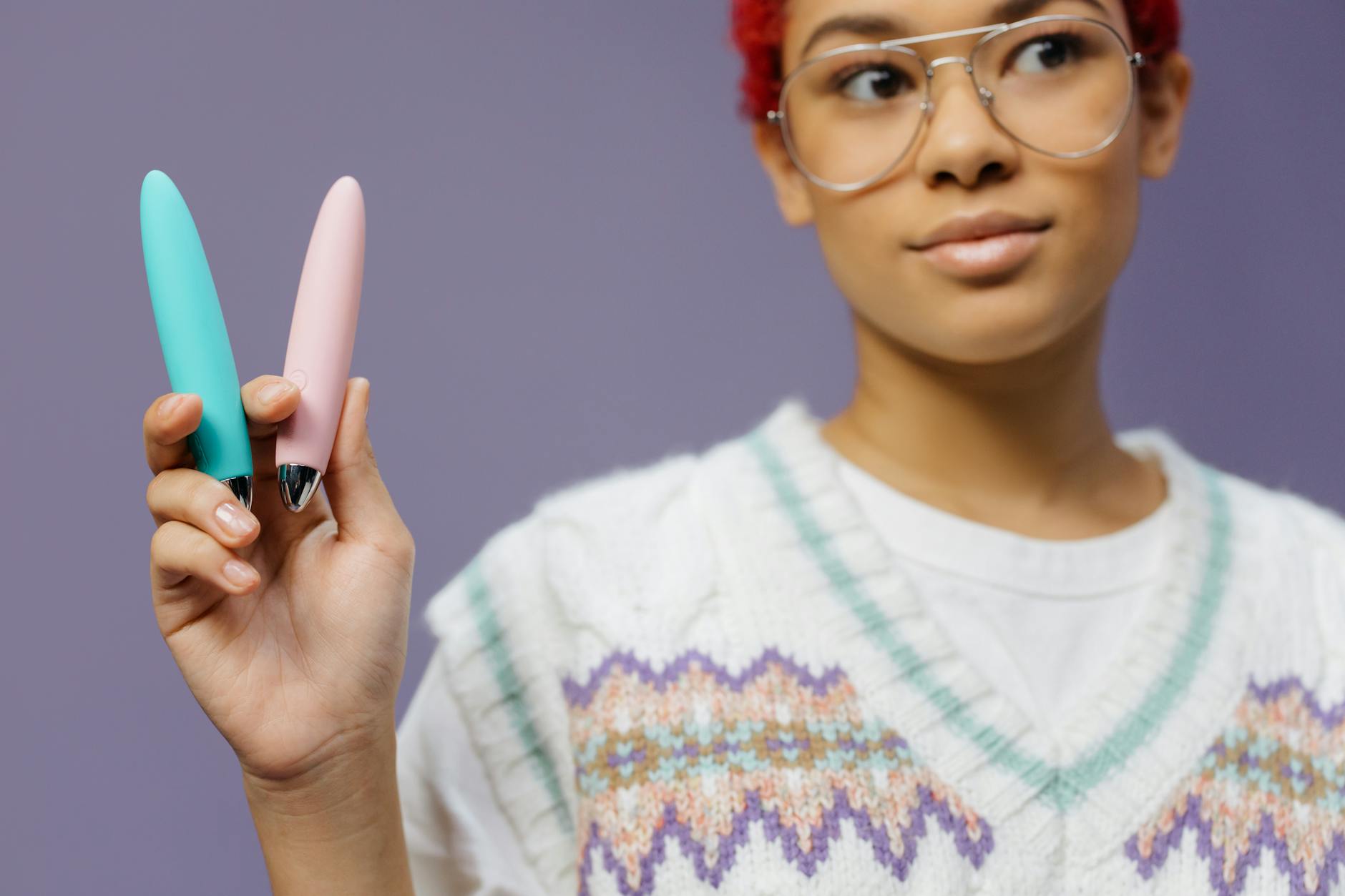 Woman holding lemon vibrators against purple background