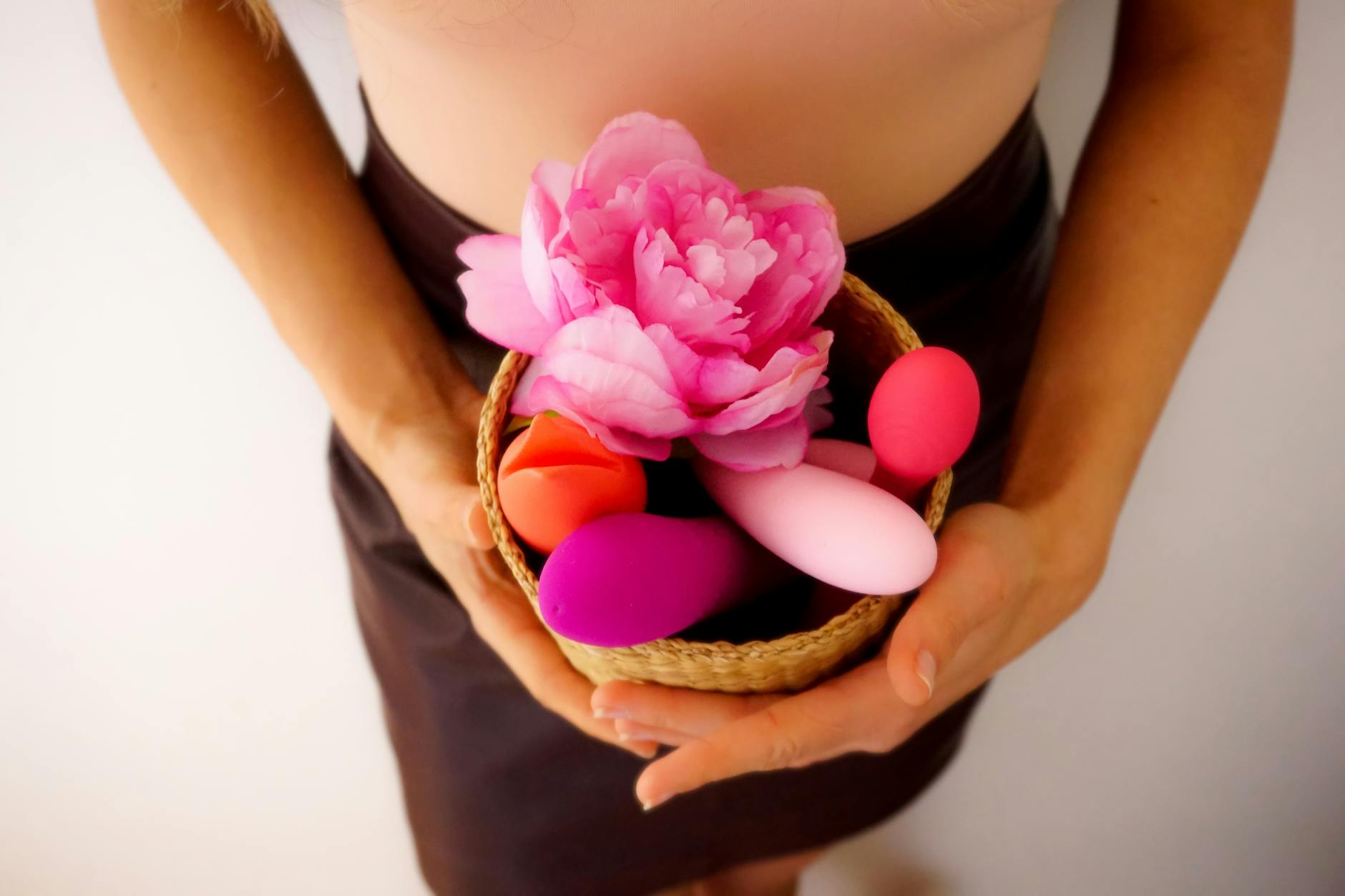 A basket containing colorful lemon vibrators and fresh flowers on a clean surface