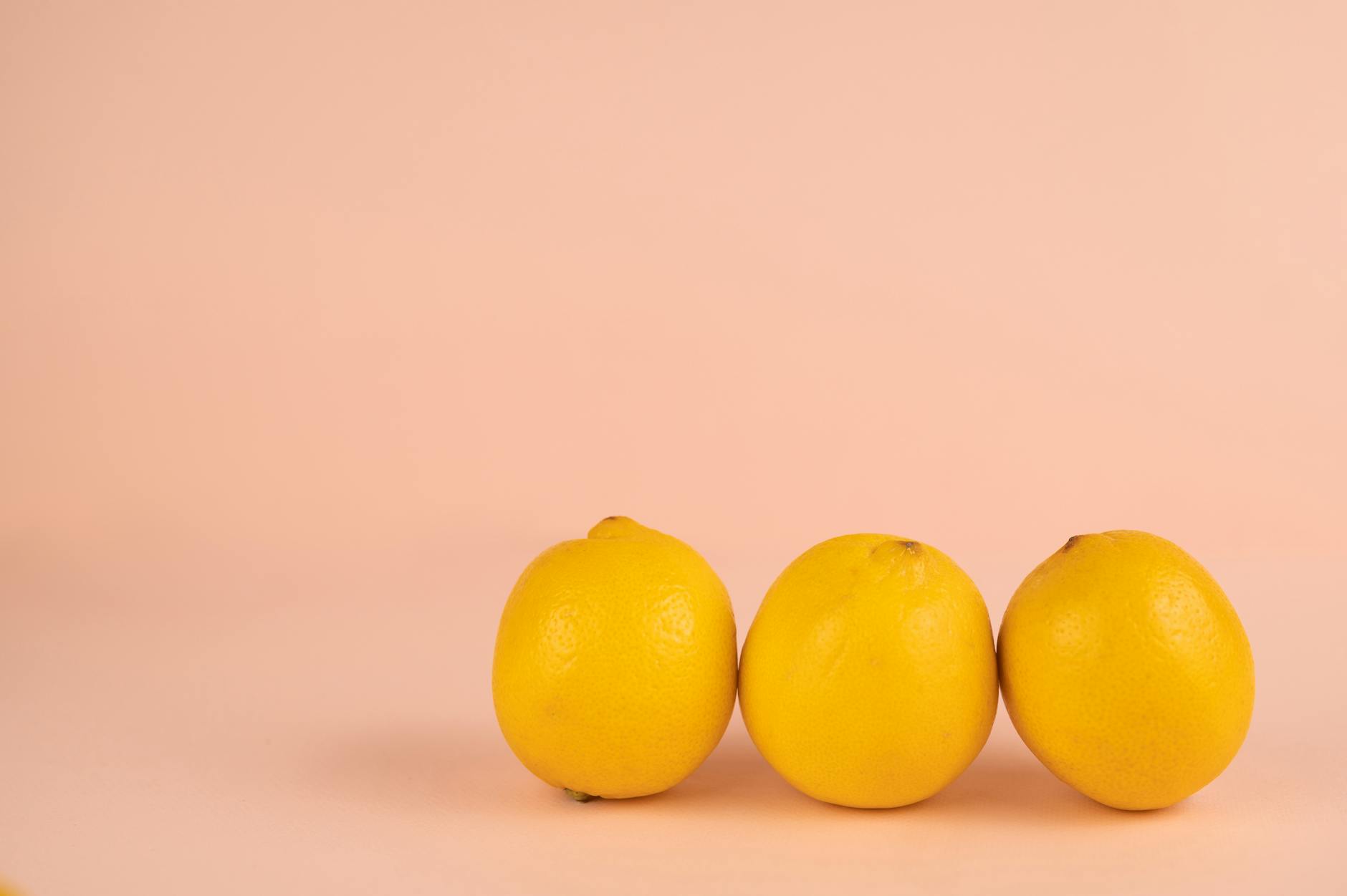 Bright yellow lemons arranged on a soft pastel background symbolizing pleasure and sensory experience